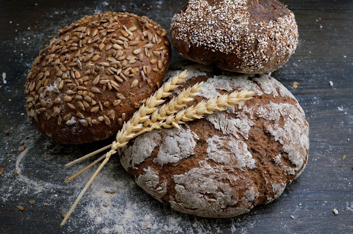 A spread of fresh pastries, sourdough loaves and cafe dishes on a rustic wooden counter